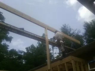 Carpenter setting a ridge beam over a new addition frame — Ice Dam Removal by Roofing Brothers in Crooksville