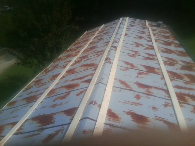 Rusted metal roof panels with new wood purlins before replacement — Storm Damage Roof Repair in Crooksville by Roofing Brothers