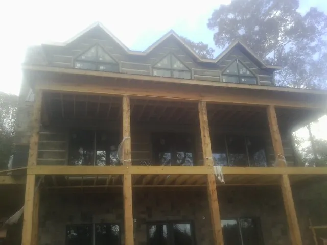 Dormers and porch framing on a large log home under construction — Roof Coating work by our crew in Crooksville