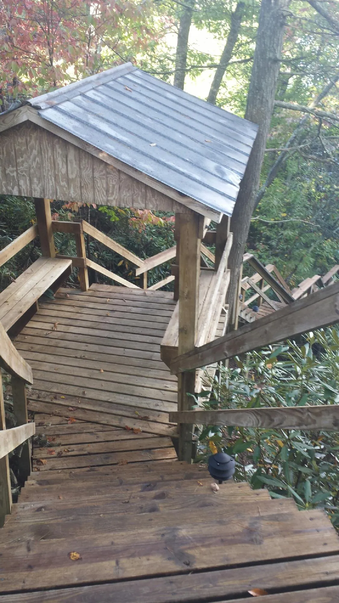 Metal roofed shelter over wooden steps on a wooded walkway — Skylight Repair & Installation work by our crew in Crooksville