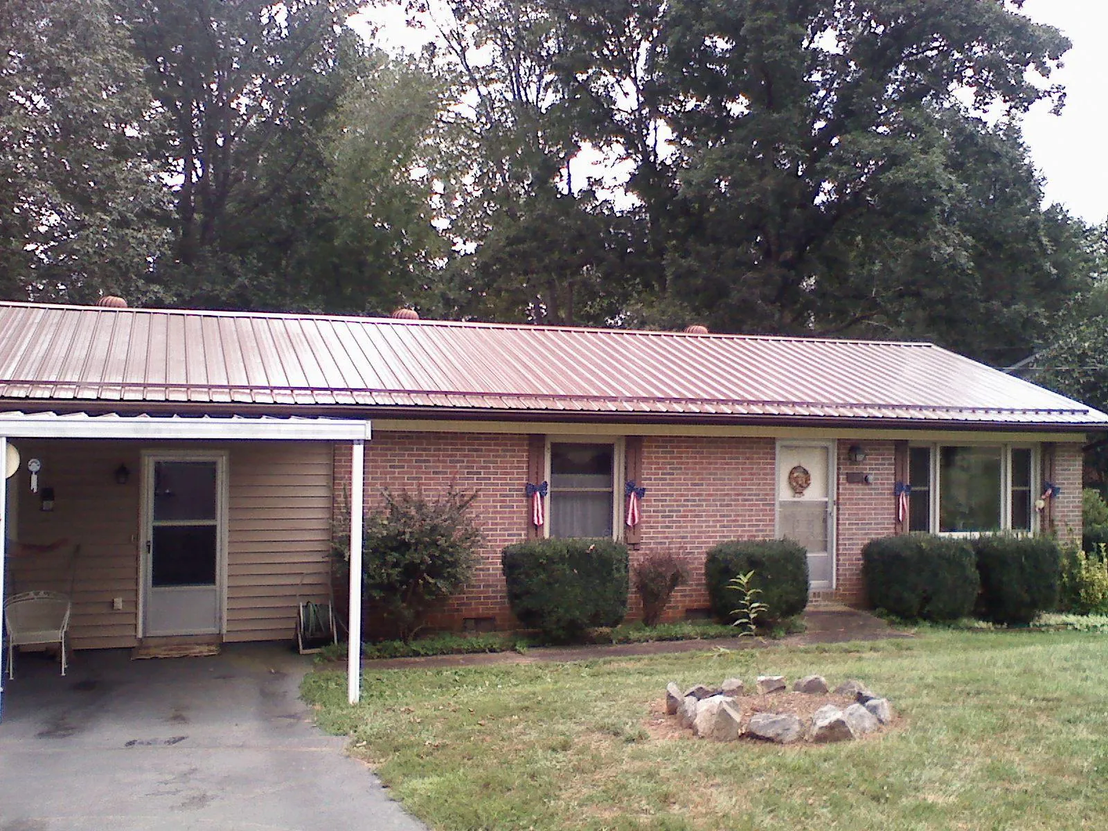 Bronze metal roof and carport on a brick ranch home — Roof Repair work by our crew in Crooksville